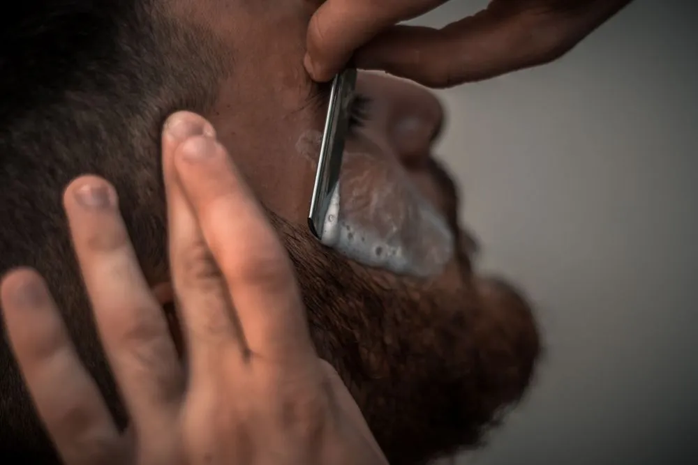 Barbier travaillant sur une barbe avec précision